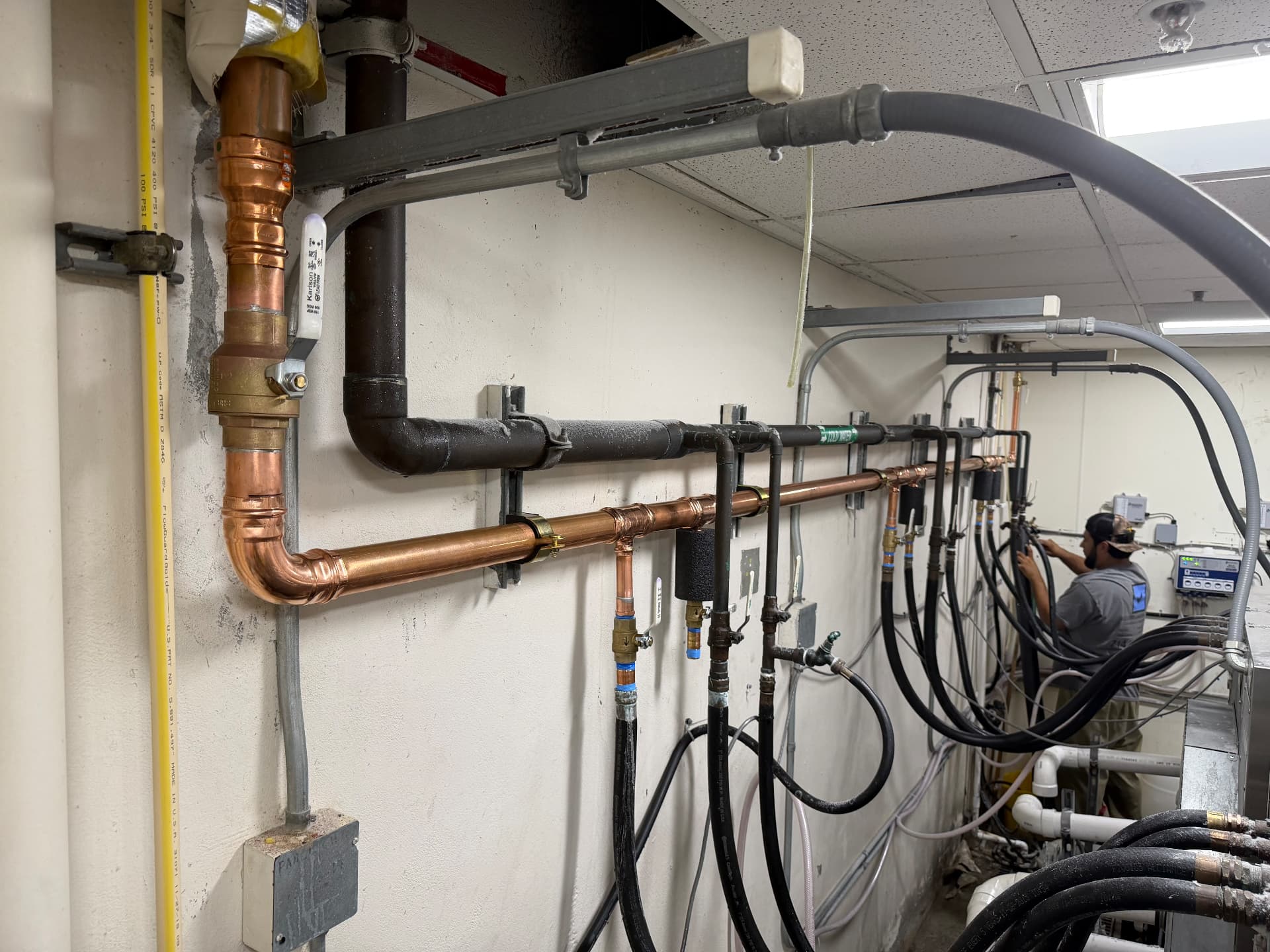 Copper and CPVC distribution manifold with valve drops installed in a commercial utility room