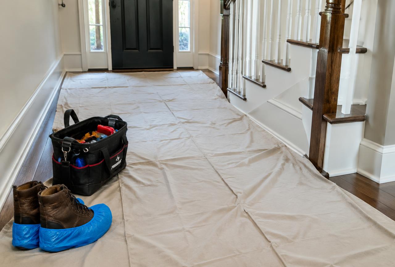 Drop cloths covering floors and shoe covers at a Klean Plumbing job site